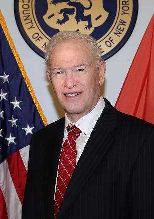 Portrait of Howard J. Kopel in front of the Nassau County seal